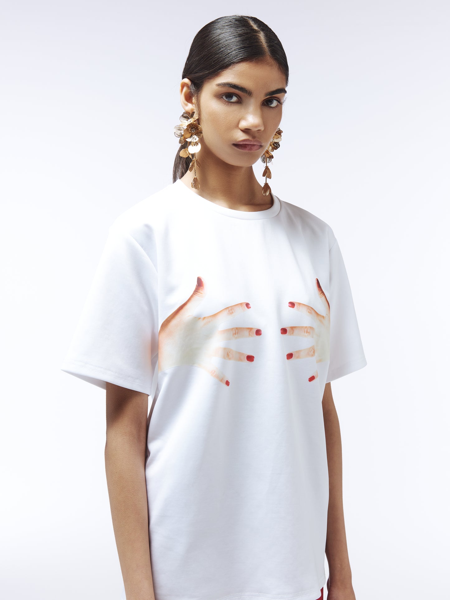 White graphic tee featuring red-painted hands, fashion statement top by Sour Figs