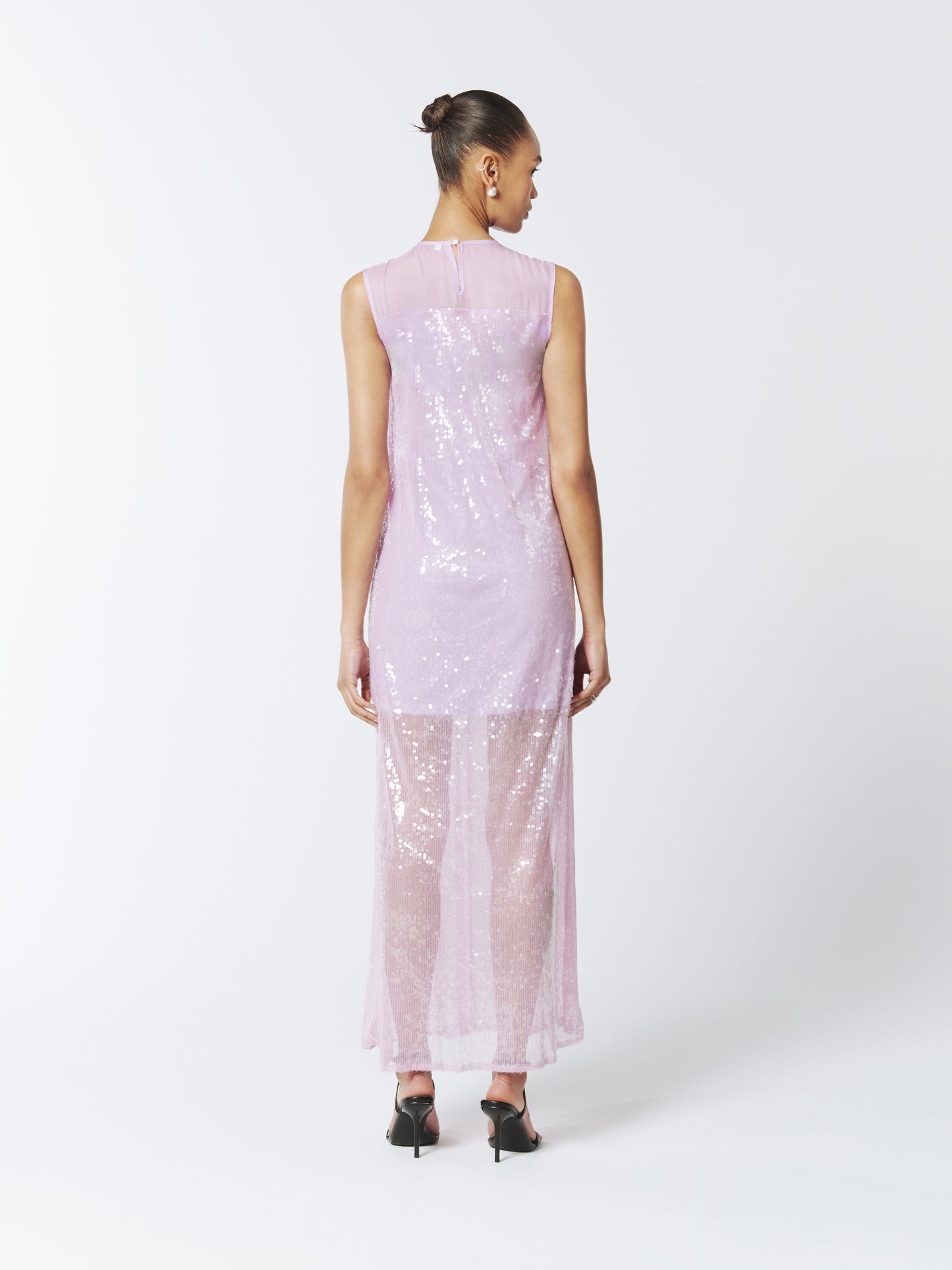 Ethereal and enchanting, this SOUR FIGS Sequined Sheer Gown in Wisteria Purple is crafted from shimmering sequined tulle, featuring a sheer neckline, sleeveless cut, and flowing silhouette.