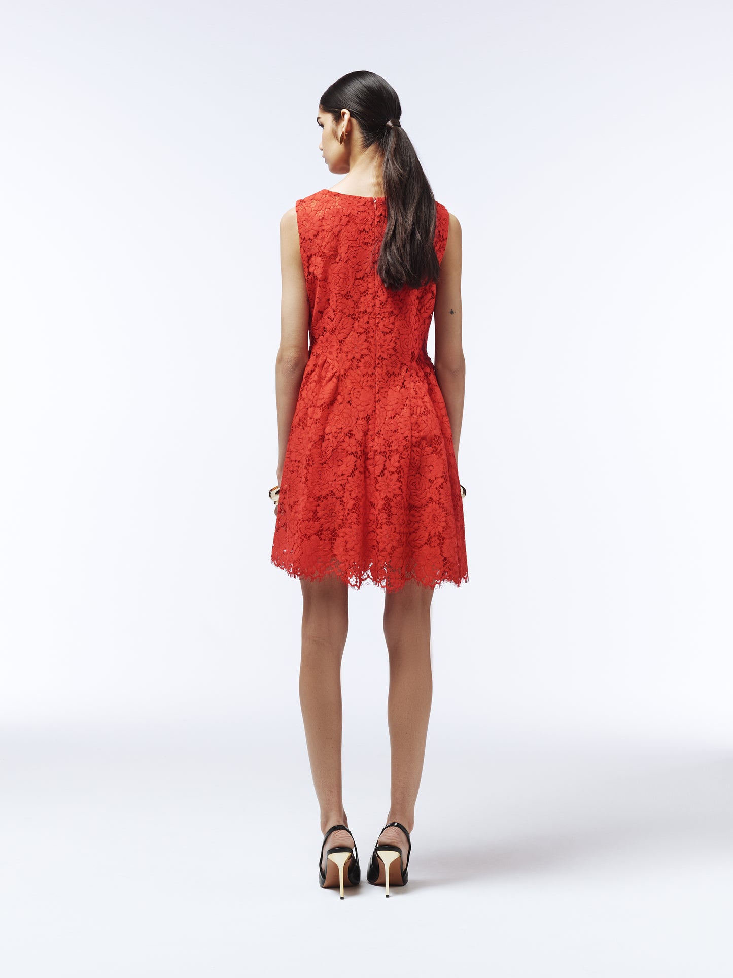 Elegant red lace mini dress styled with black heels and statement earrings