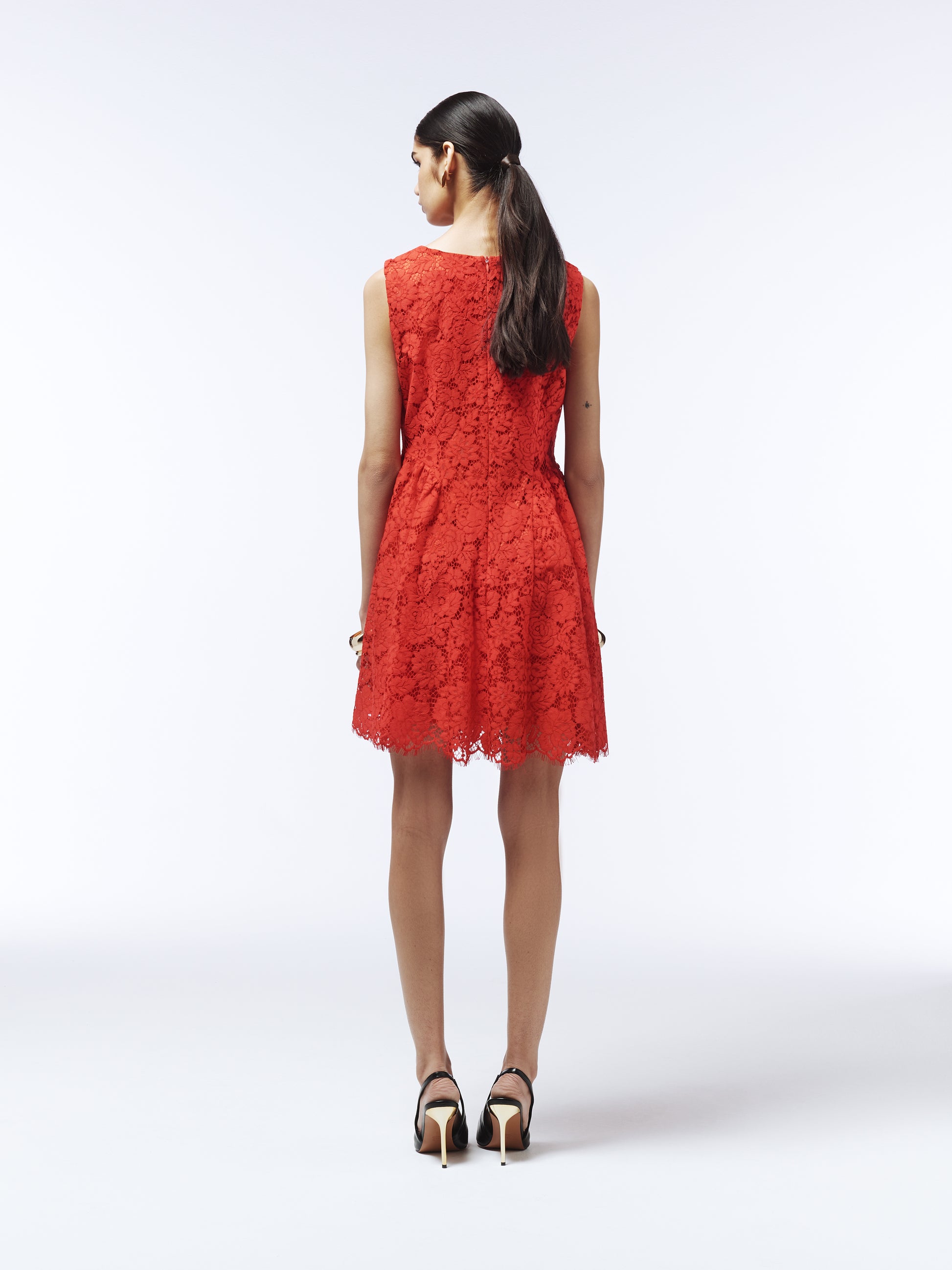 Elegant red lace mini dress styled with black heels and statement earrings