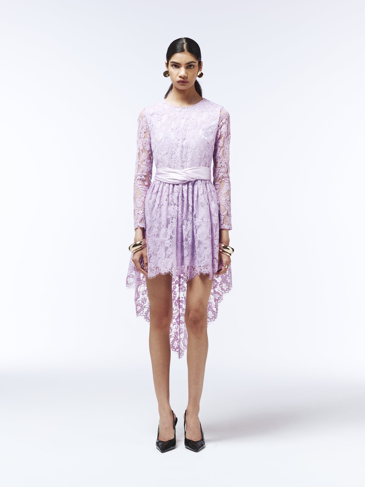Back view of lilac lace occasion dress featuring sheer long sleeves and asymmetric hem.