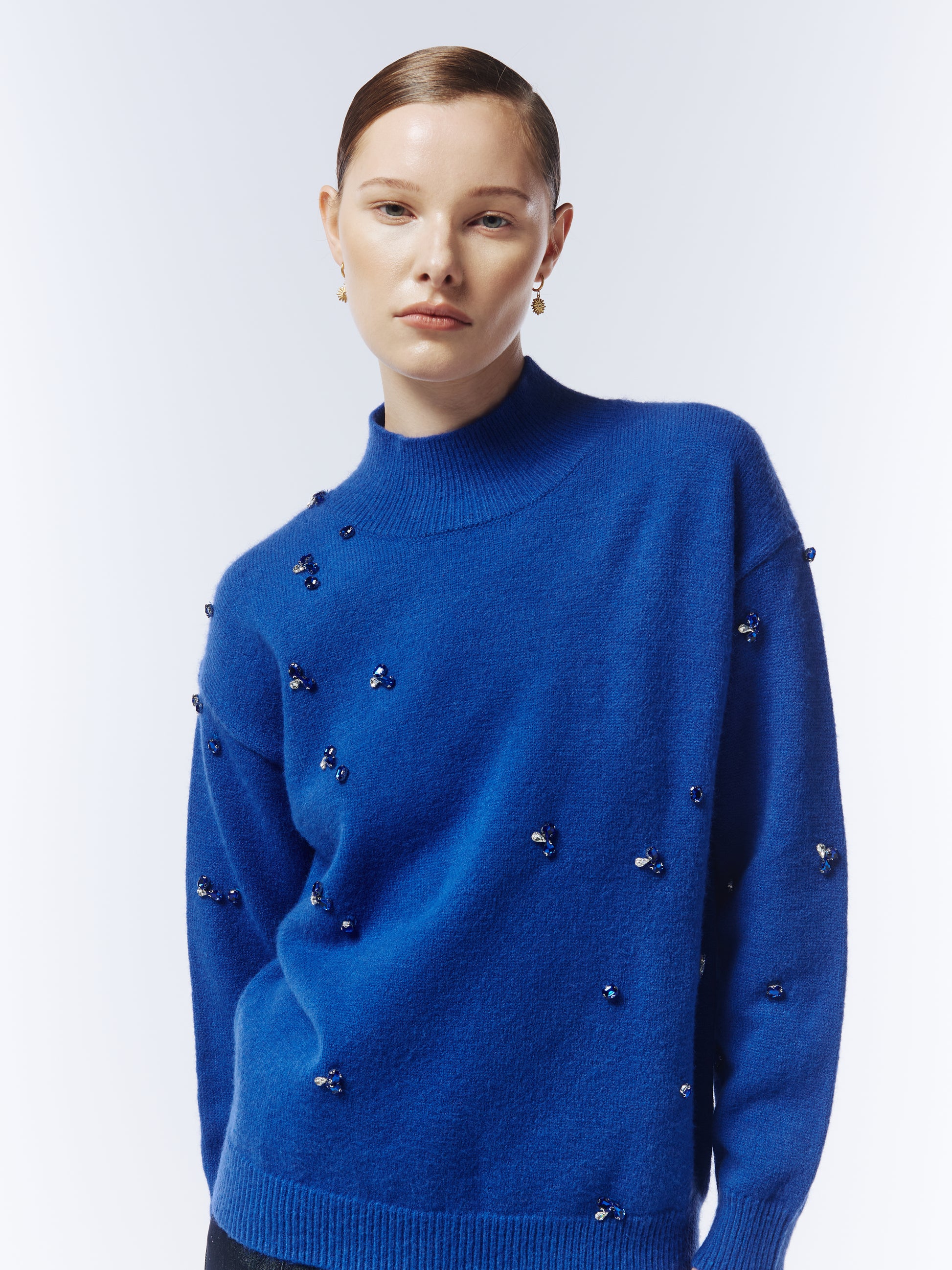 Close-up of hand-stitched gemstone detailing on the sapphire blue Sour Figs jumper.