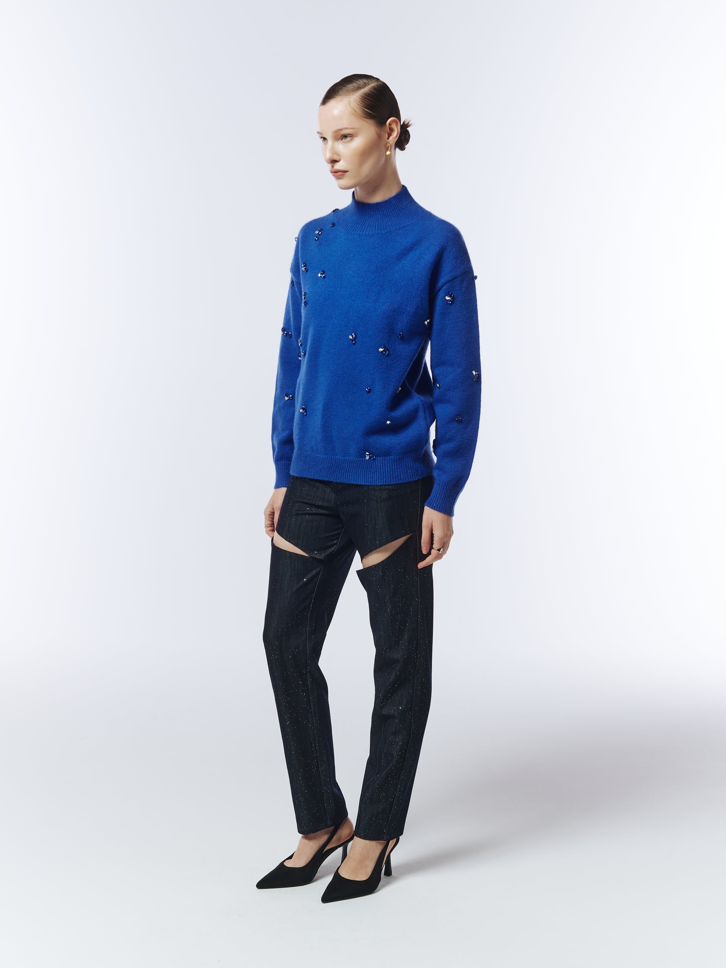 Side view of model in sapphire blue hand-stitched gemstone jumper by Sour Figs.