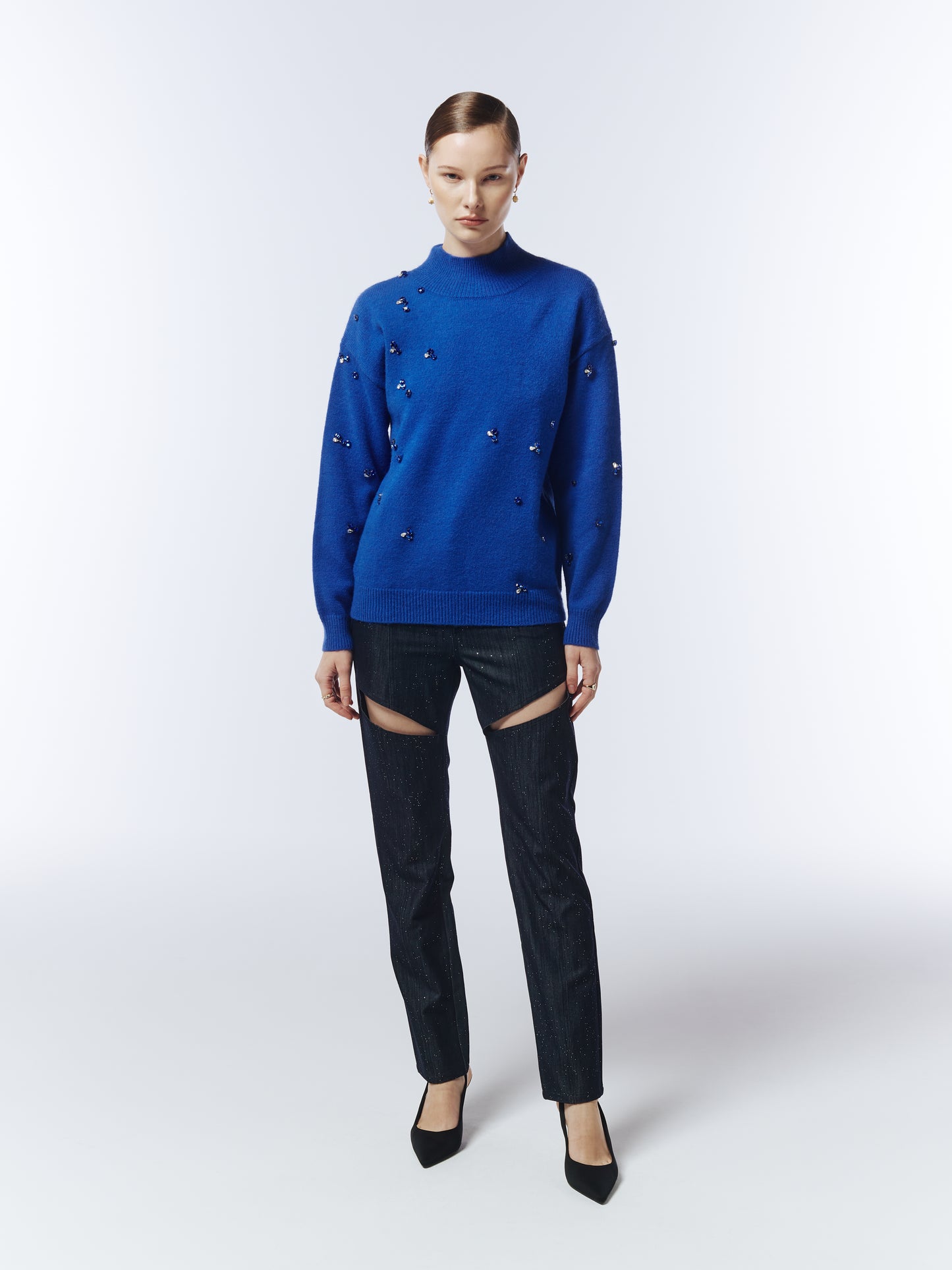 Model wearing the Sour Figs sapphire blue gemstone jumper paired with dark cut-out trousers.