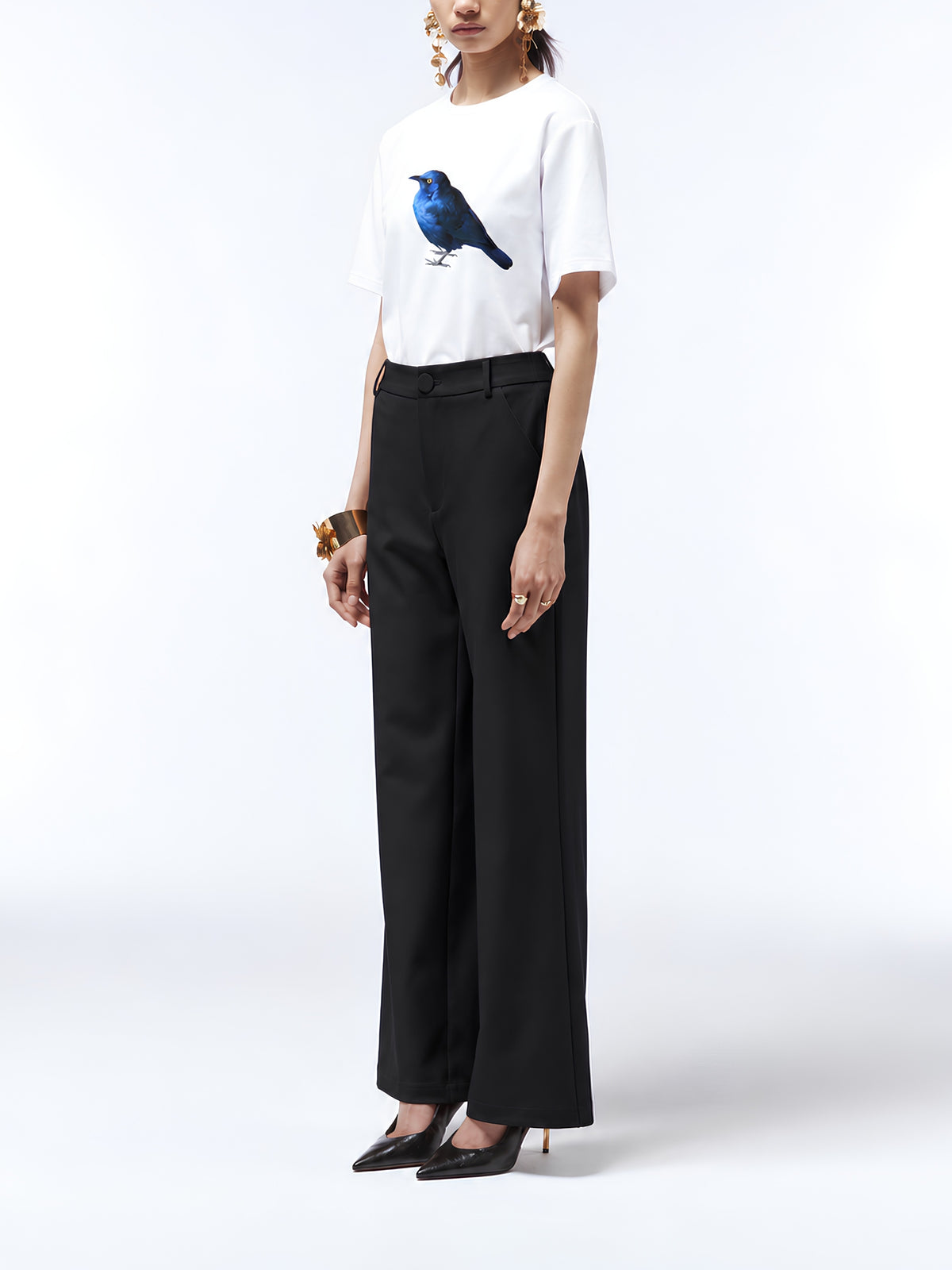 The blue starling print on a white T-shirt tucked into black tailored trousers.