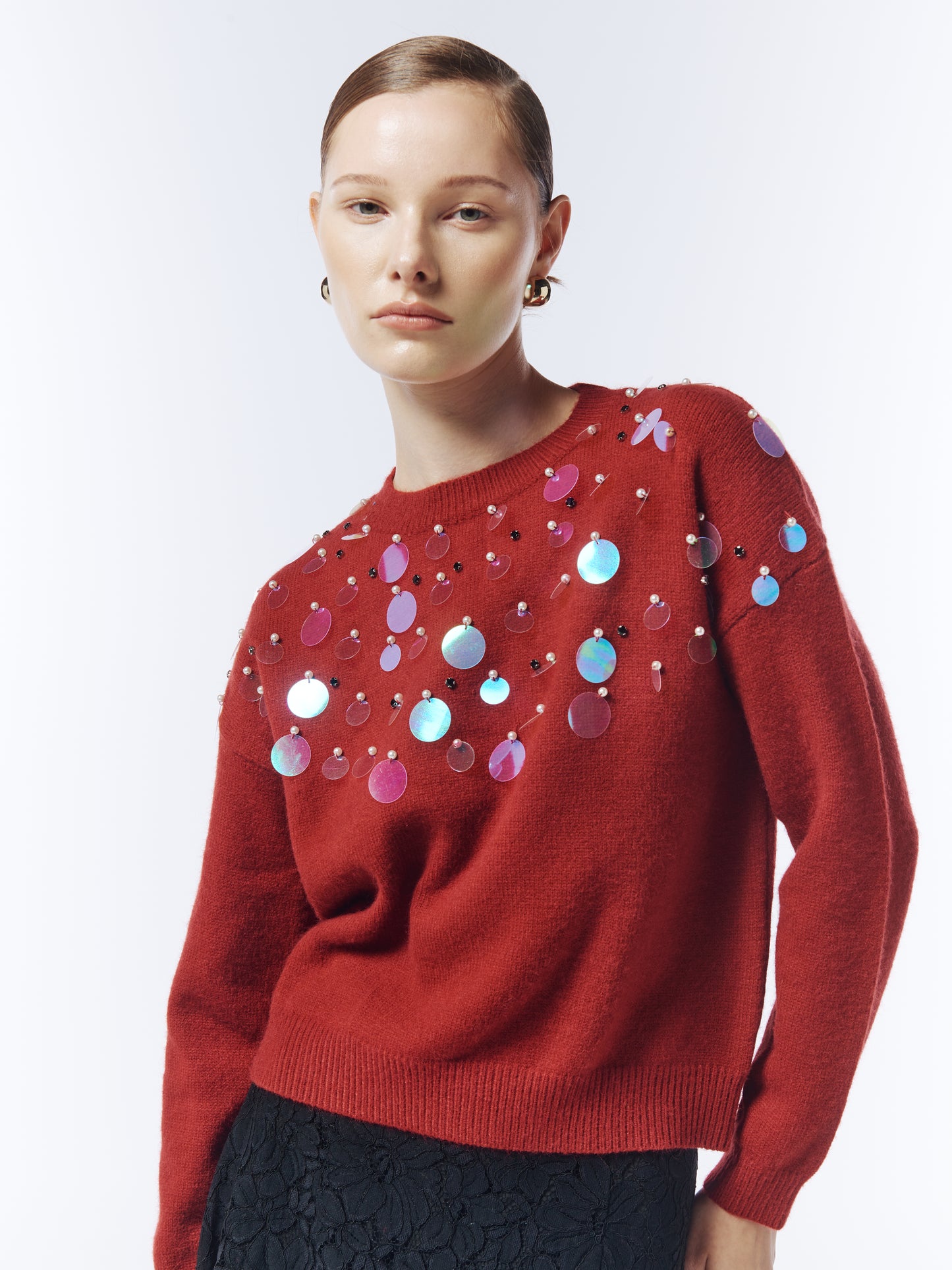 Close-up of iridescent sequin embellishments on SOUR FIGS red jumper.