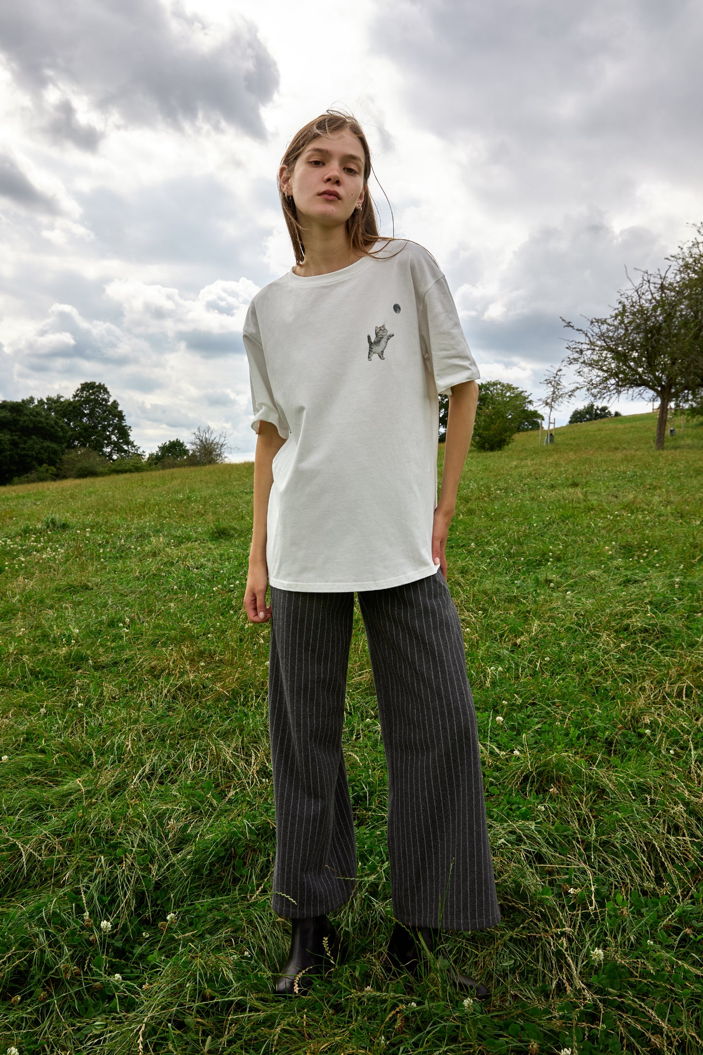 Minimalist white graphic tee featuring playful kitten and moon embroidery by SOUR FIGS.