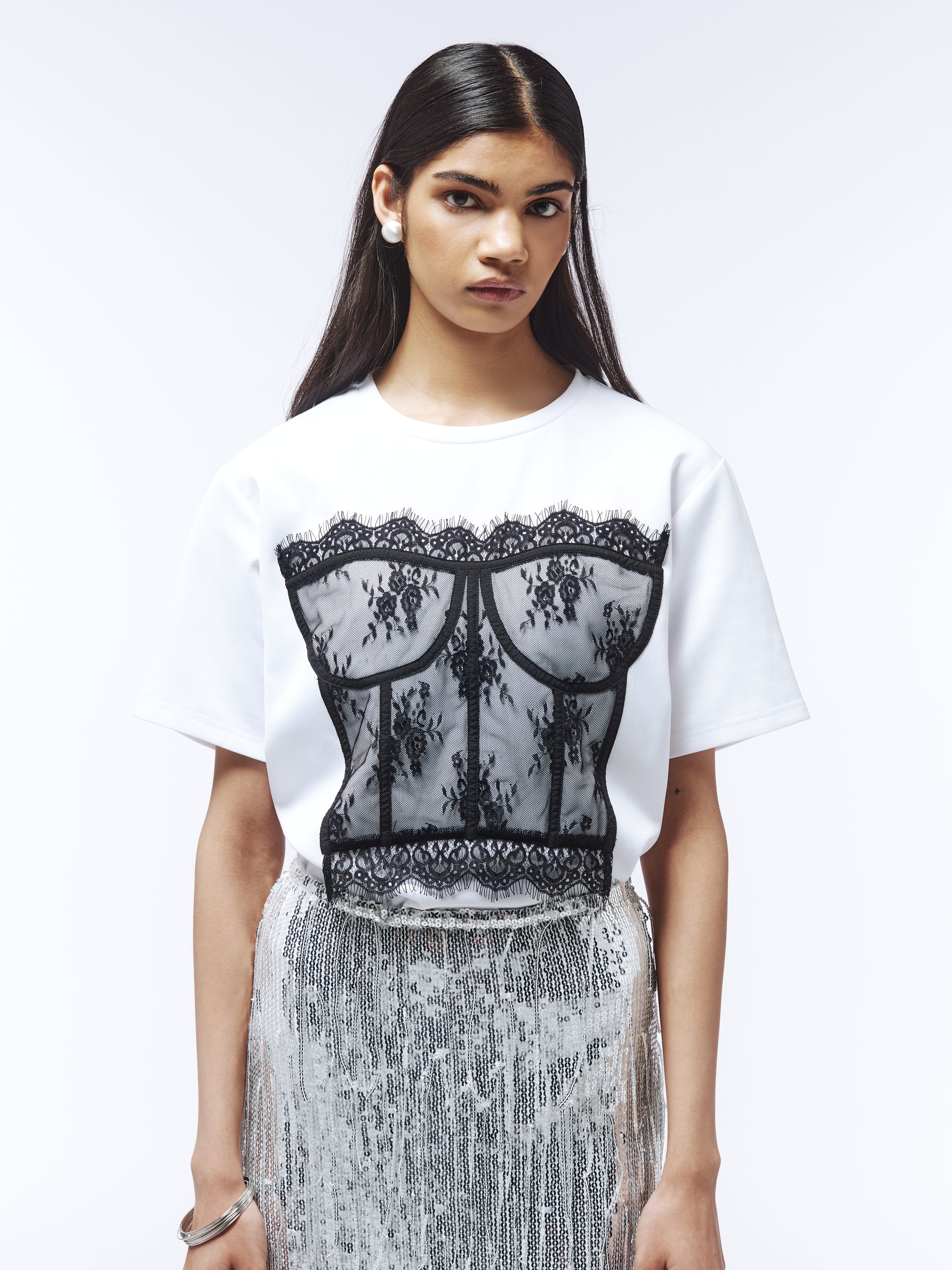 Optical white tee featuring contrast floral lace bustier overlay