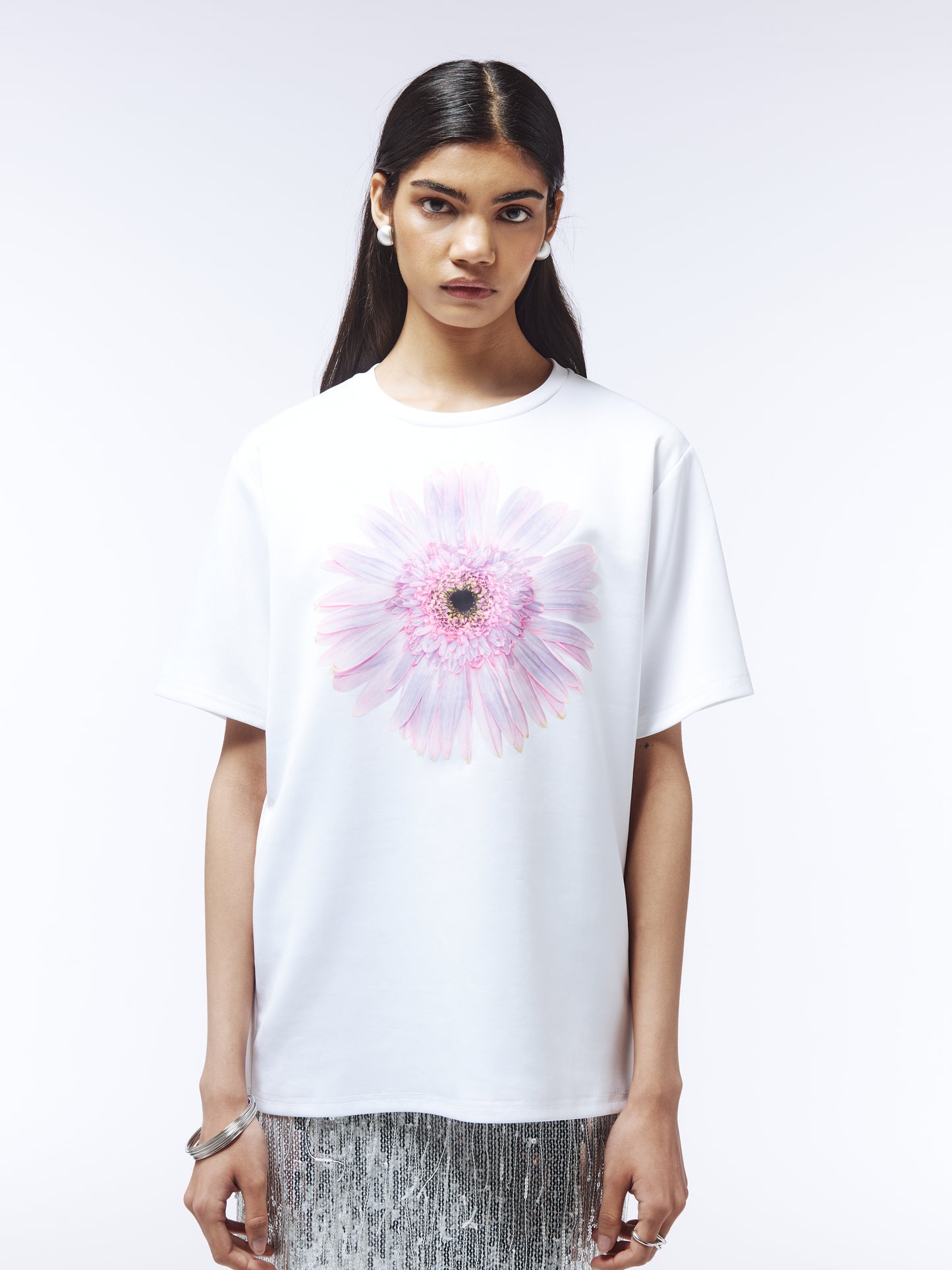 Model wearing white floral graphic T-shirt with pastel-toned bloom