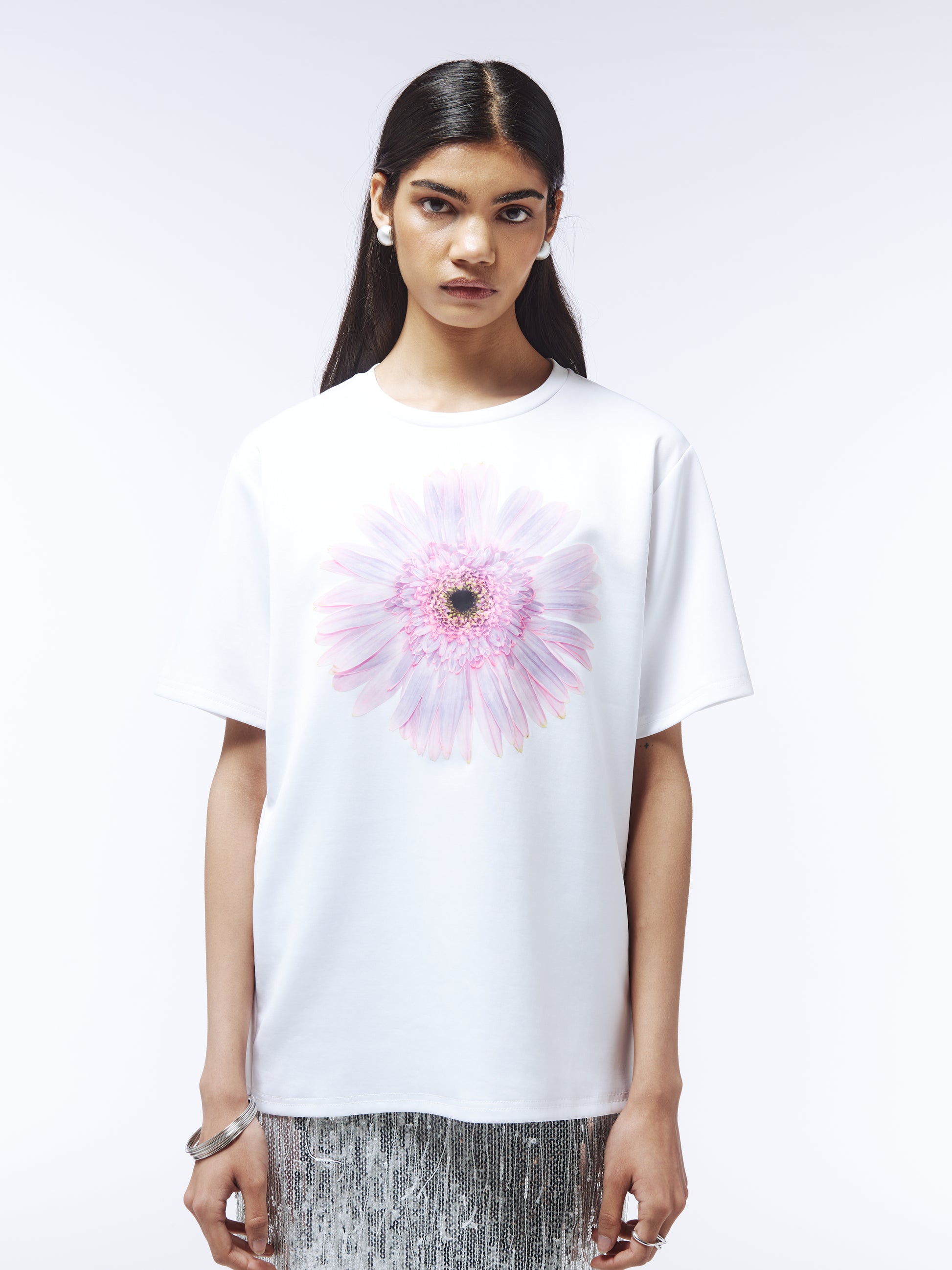 Model wearing white floral graphic T-shirt with pastel-toned bloom