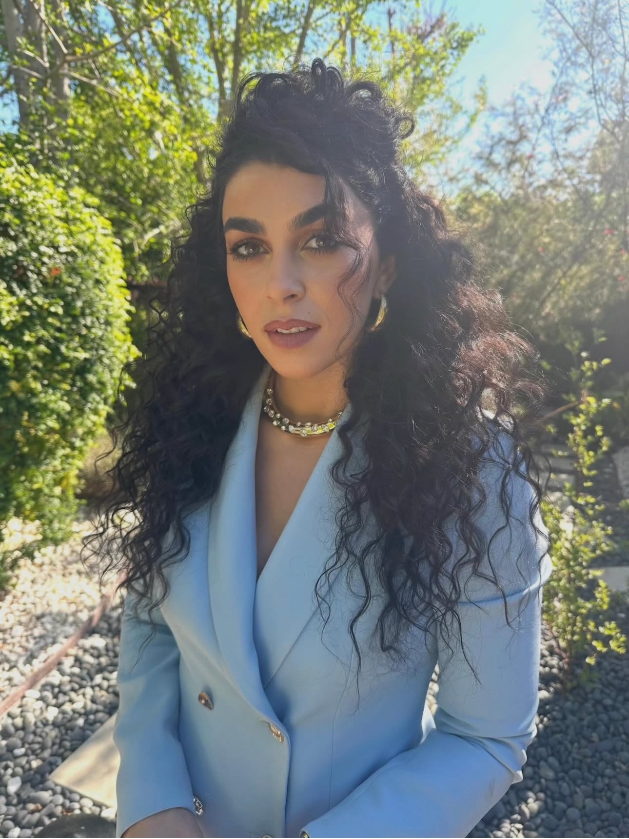NATACHA KARAM wears SOUR FIGS Evil Eye Brooch Tailored Blazer in Powder Blue, finished with collector’s buttons.