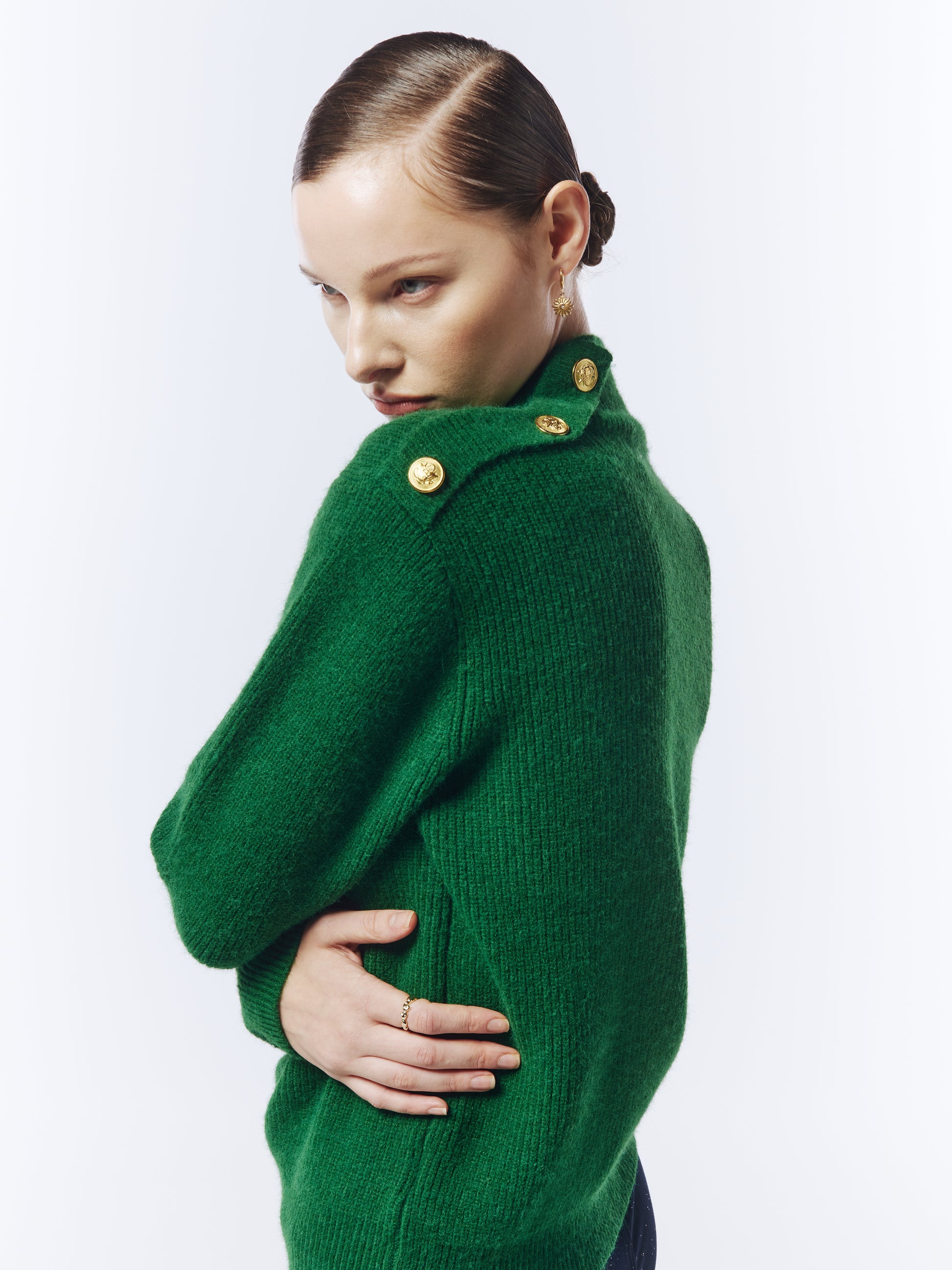 Editorial shot of model styling a pine green jumper