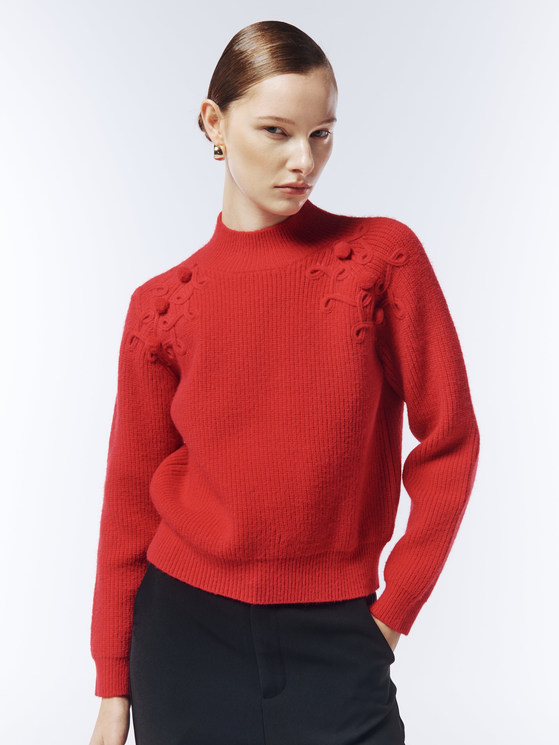 Close-up of integrated cable and bobble-knit detailing on shoulder of crimson jumper from SOUR FIGS