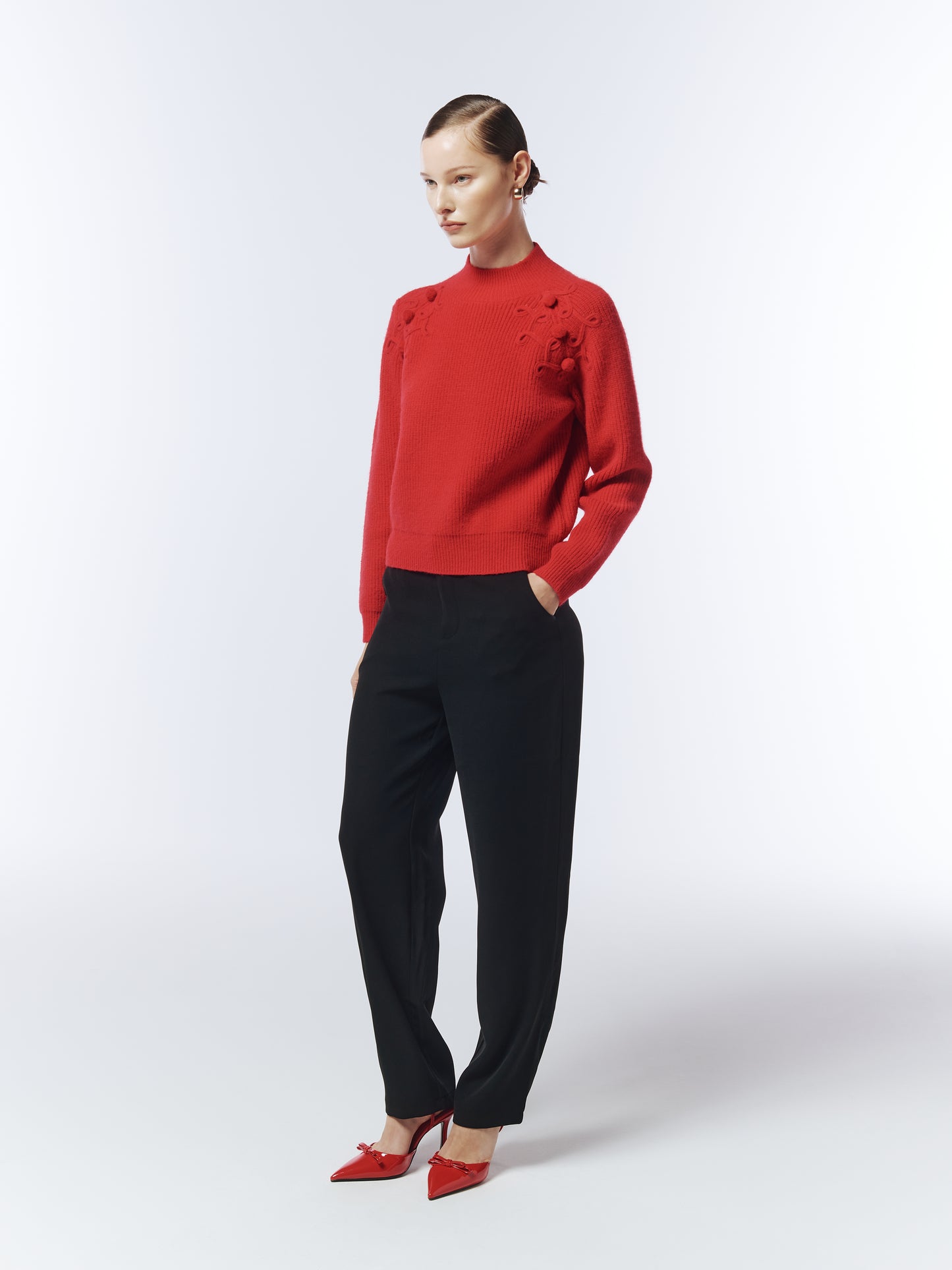 Side view of crimson bobble-knit jumper showing textured shoulder pattern.