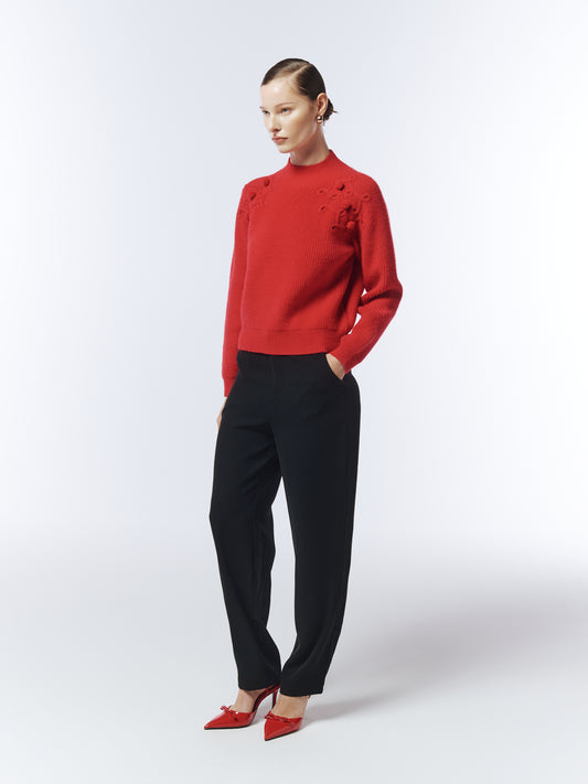 Side view of crimson bobble-knit jumper showing textured shoulder pattern.
