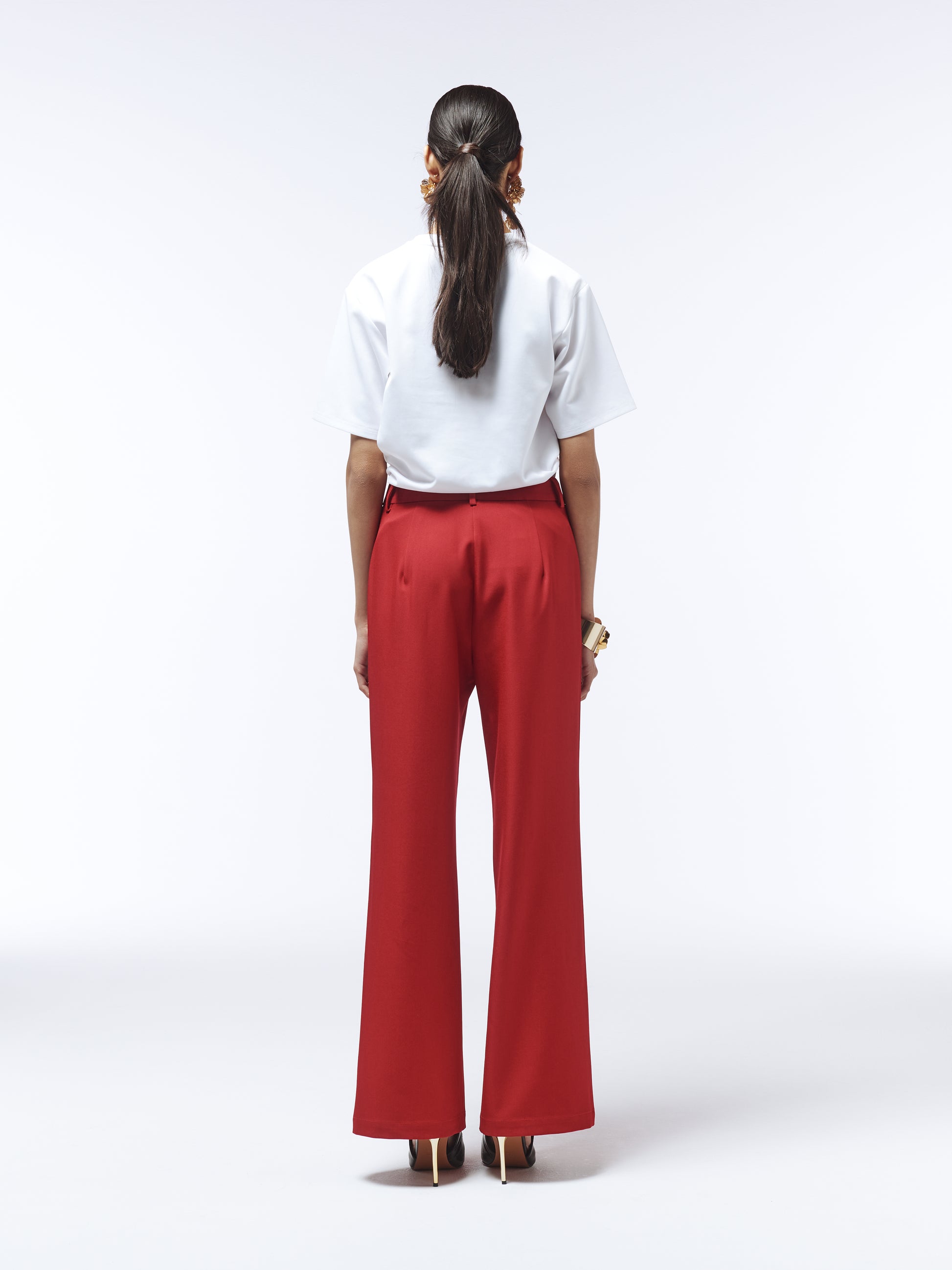 Back view of SOUR FIGS wide-leg trousers in vivid burgundy highlighting streamlined tailoring.