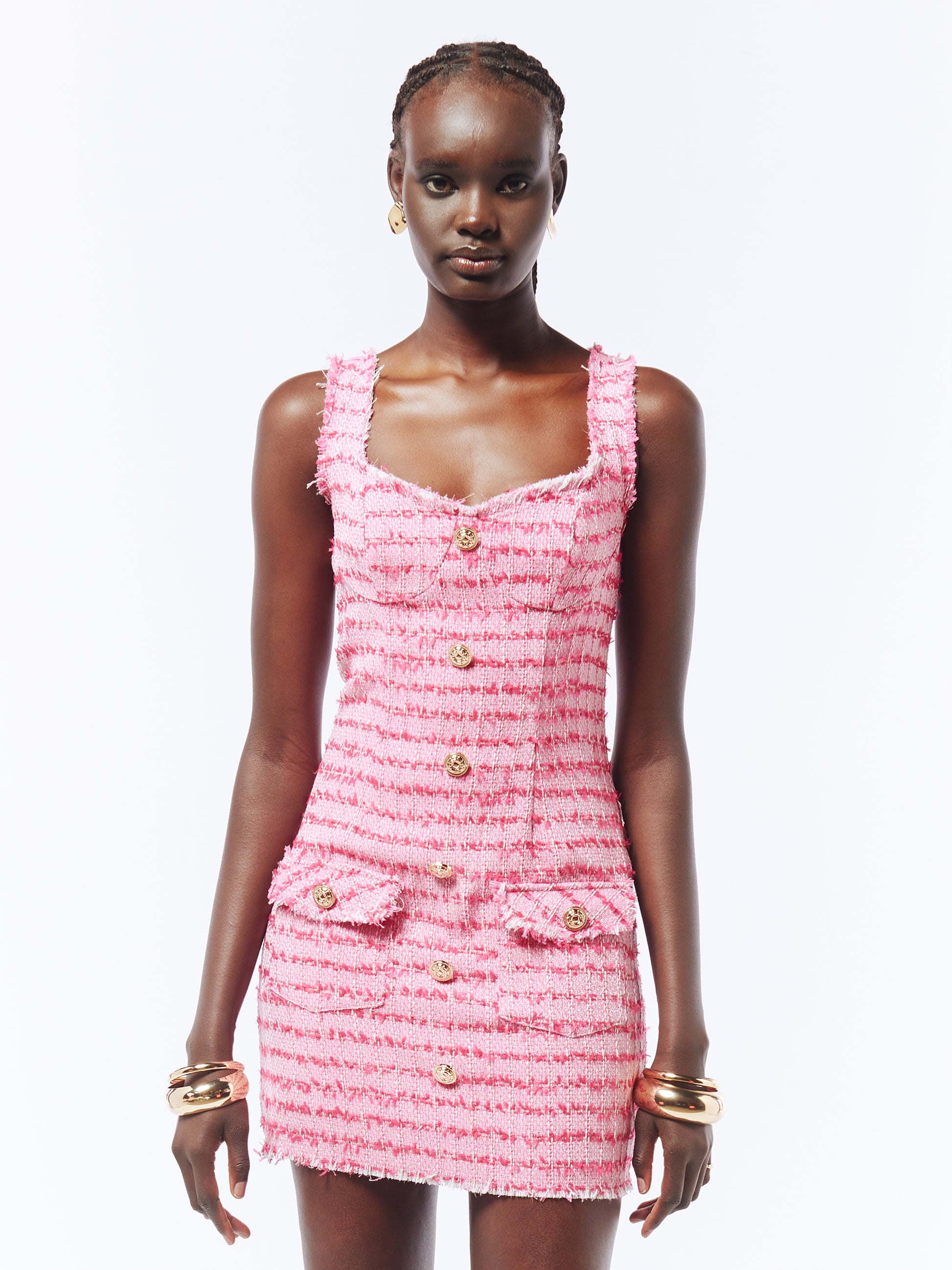 Classic meets contemporary in this pink tweed mini dress, designed with a V-neck, frayed edges, gold-tone buttons, and a flattering thigh-length cut.