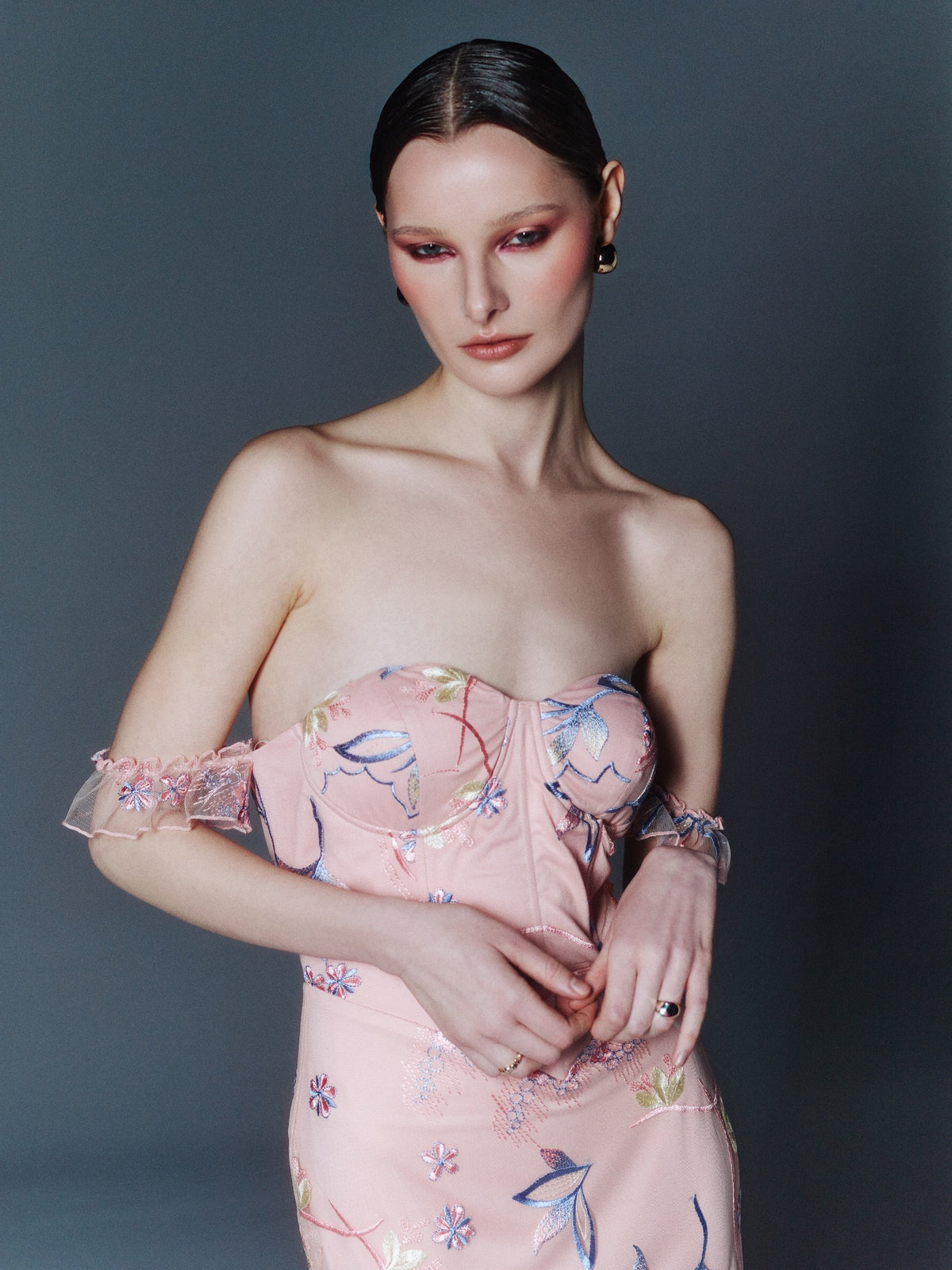 Blush pink floral-embroidered maxi dress, close-up of the sweetheart bustier bodice and off-shoulder mesh ruffles.