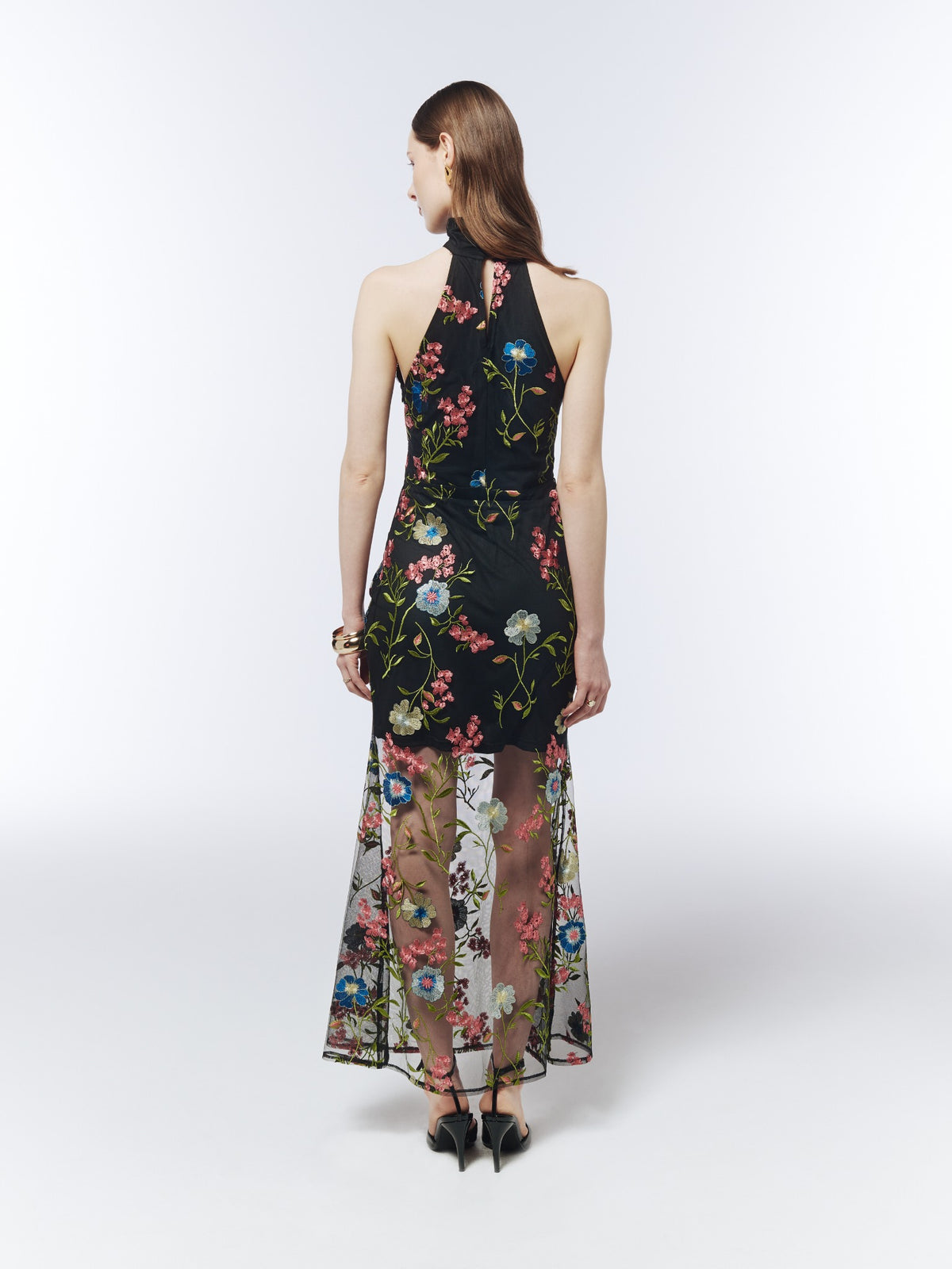 Black floral-embroidered halterneck maxi dress, back model view showing the neck keyhole and sheer embroidered skirt.