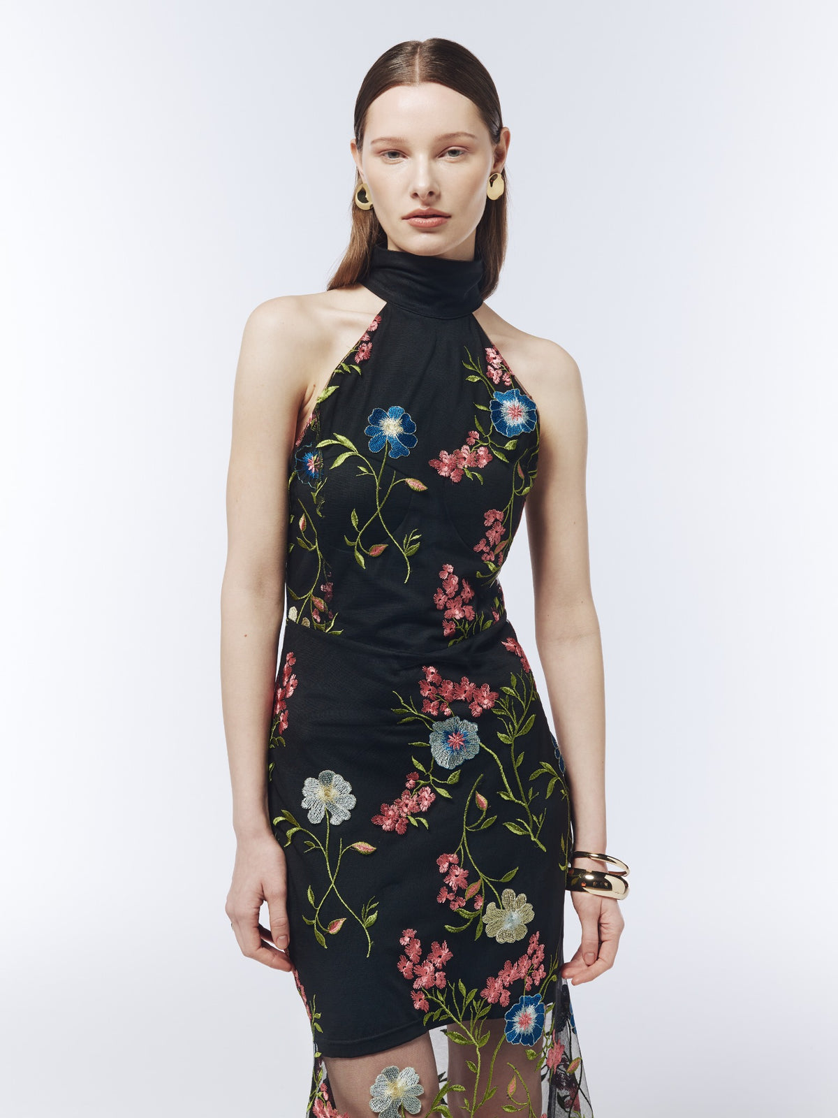 Black floral-embroidered halterneck dress, close-up showing the high collar and pink, blue and ivory flowers with green stems.