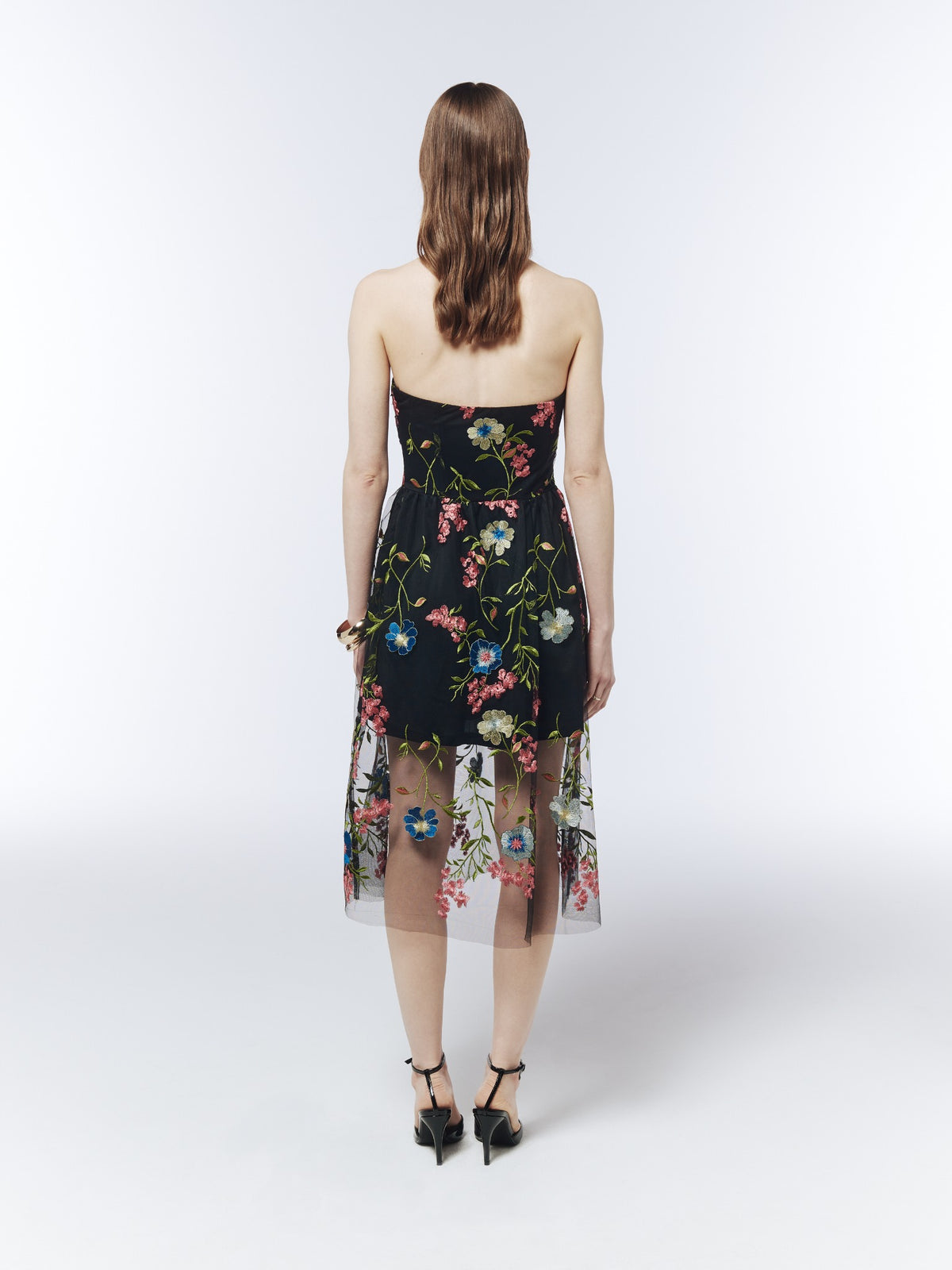 Black floral-embroidered strapless midi dress, back model view showing the straight neckline and sheer embroidered hem.