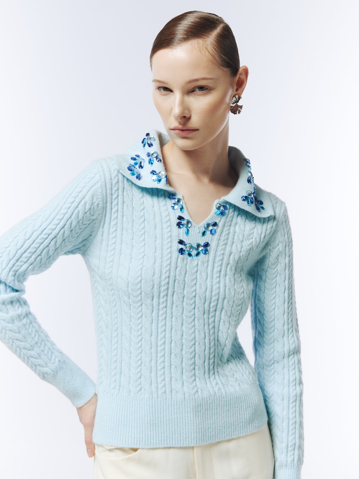 SOUR FIGS hand-embellished cable-knit polo jumper in ice blue, close-up showing faceted jewels around the collar and V neckline.