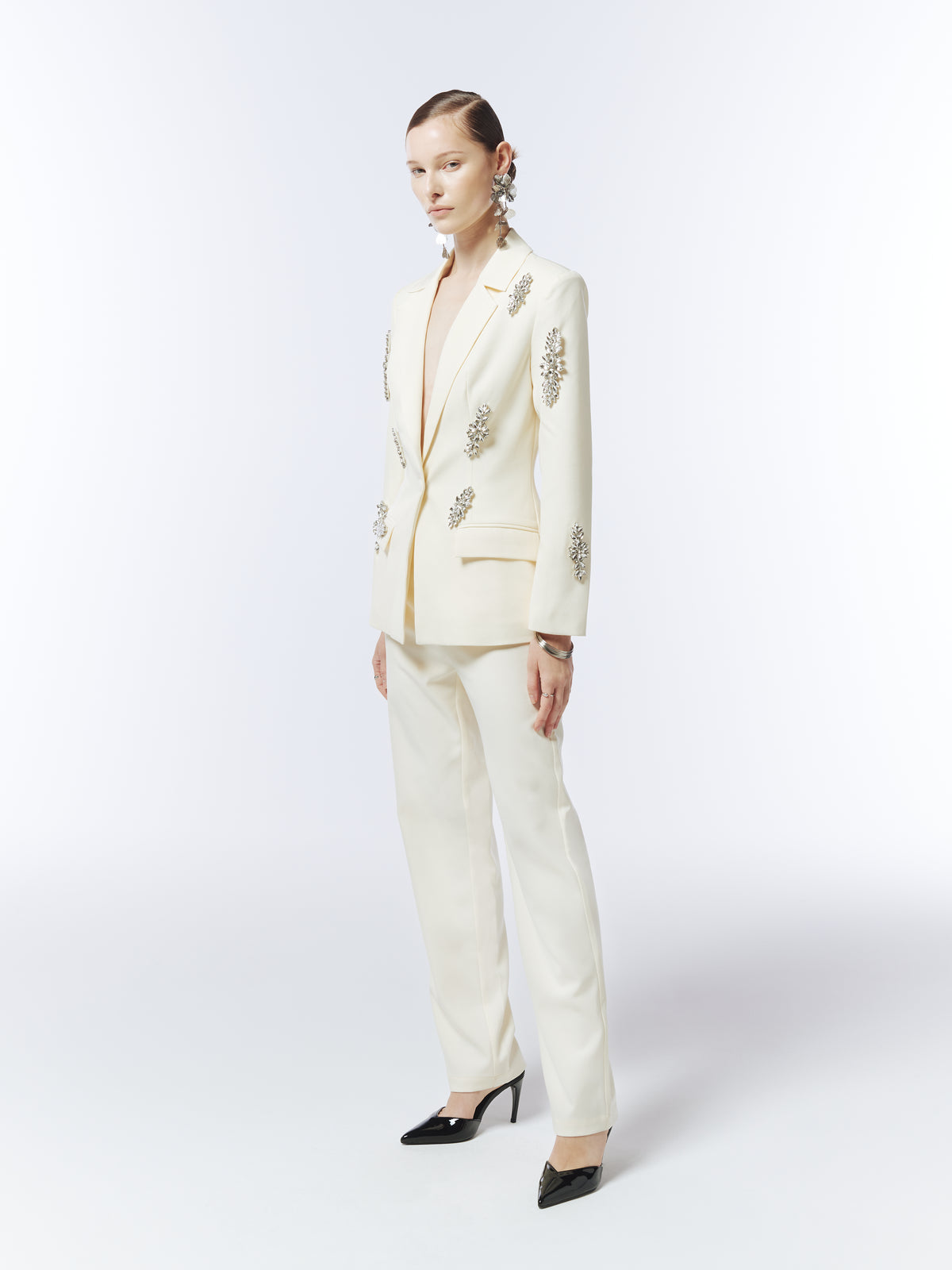 Three-quarter view of SOUR FIGS tailored tapered trousers in soft ivory, showing the leg silhouette with the coordinating blazer.